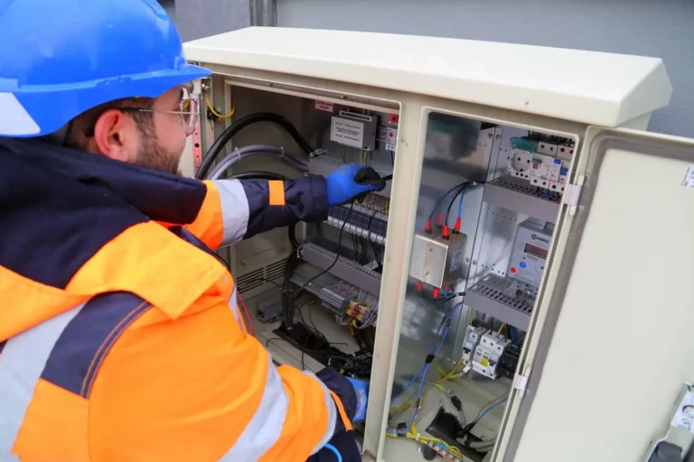 Un instalador electricista trabaja en un cuadro eléctrico